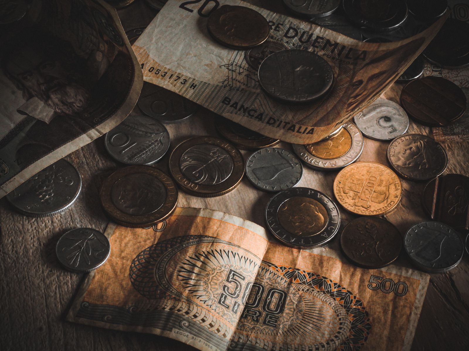 Billets de banque anciens et monnaies de collection sur un plateau en bois